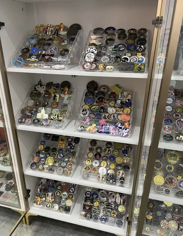 A factory sample archive displaying custom enamel pins, metal badges, medals, and small branded pieces